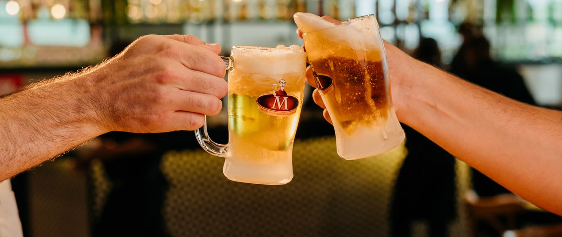 Brinde com canecas de chopp em mesa do Boteco do Manolo